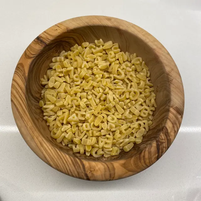 Alphabet in a round wooden bowl