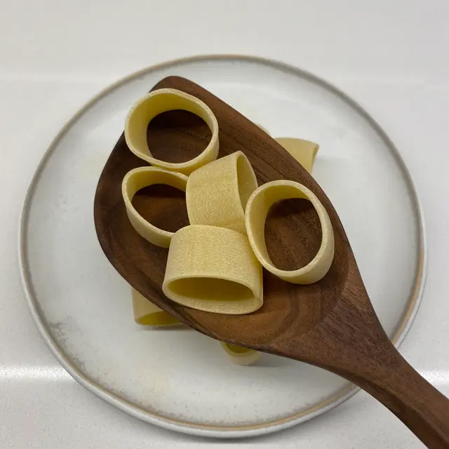 Calamarata in a wooden serving spoon