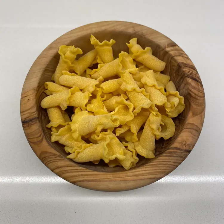 Campanelle in a round wooden bowl