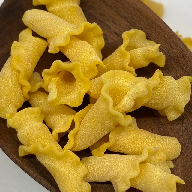 A close up shot of Campanelle in a wooden serving spoon