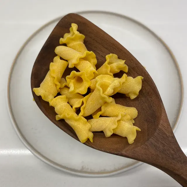 Campanelle in a wooden serving spoon