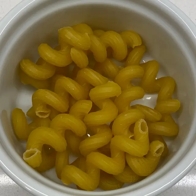 A close up shot of Cavatappi in a round white ramekin