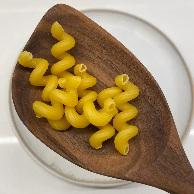 Cavatappi in a wooden serving spoon