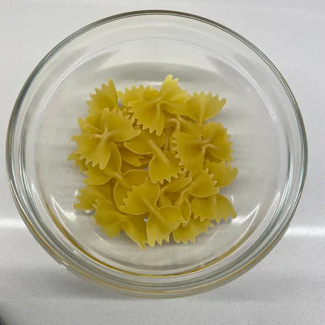 Farfalle in a clear round glass bowl