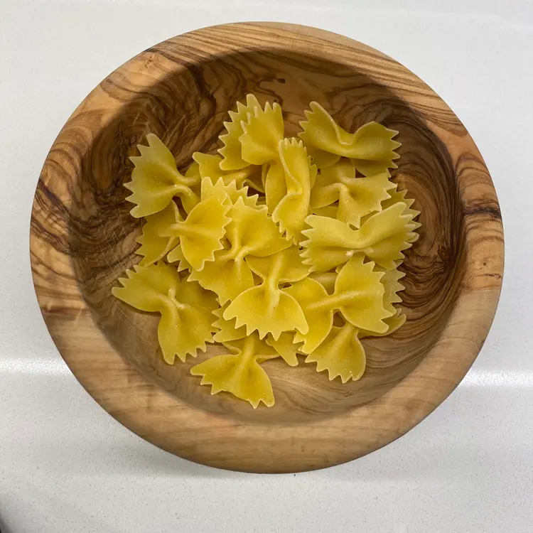 Farfalle in a round wooden bowl