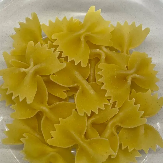 A close up shot of Farfalle on a round white plate