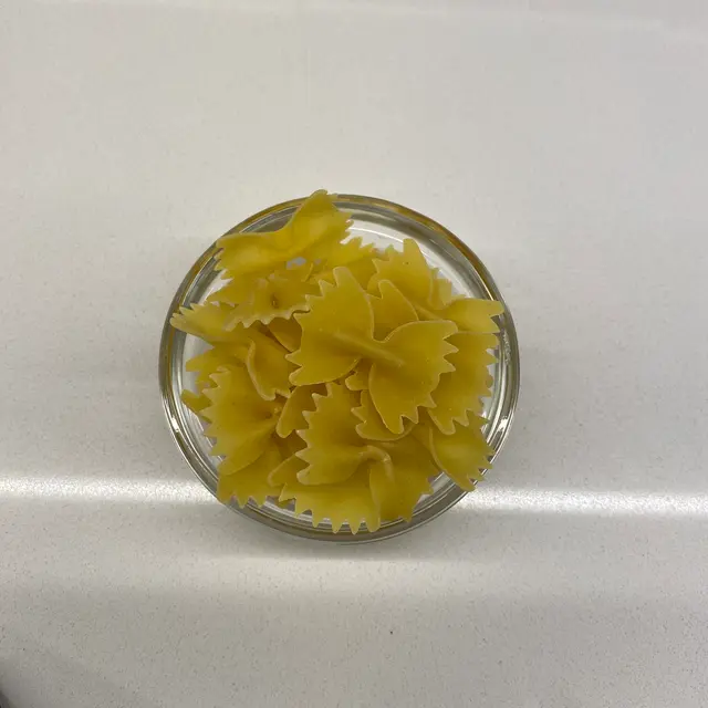 Farfalle in a small round white glass bowl