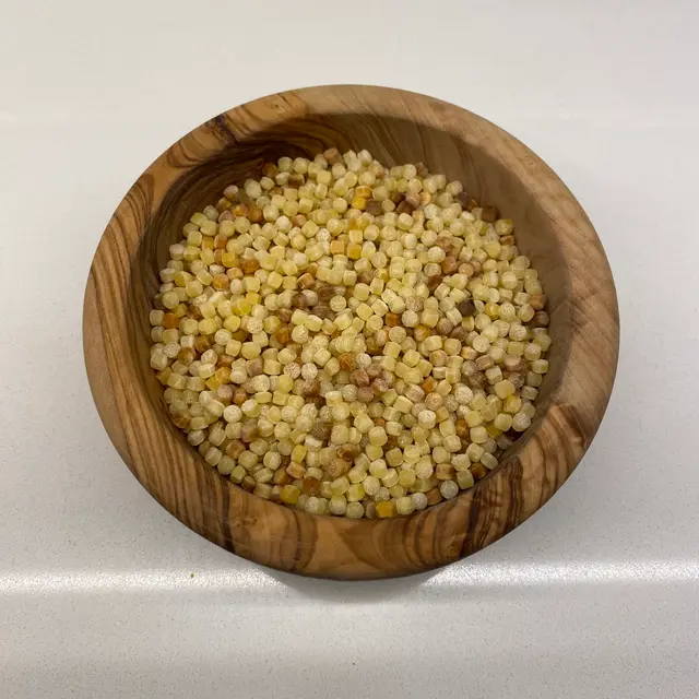 Fregola in a round wooden bowl