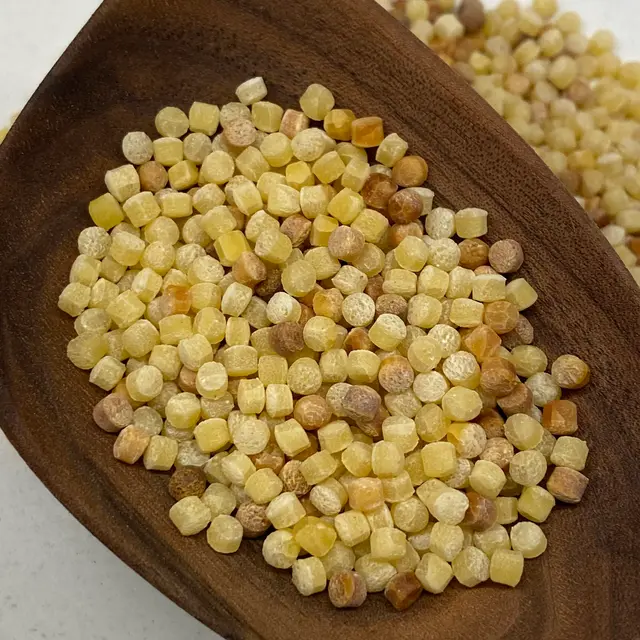 A close up shot of Fregola in a wooden serving spoon