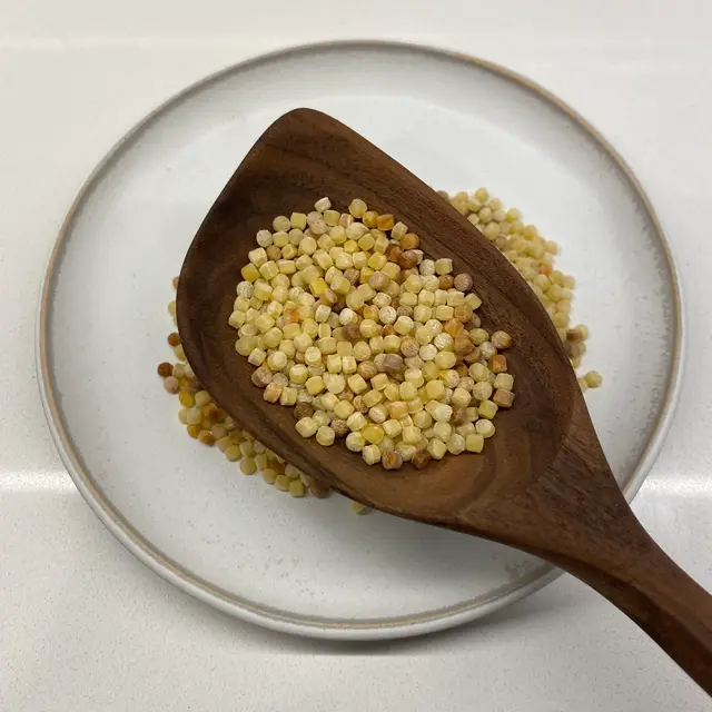 Fregola in a wooden serving spoon