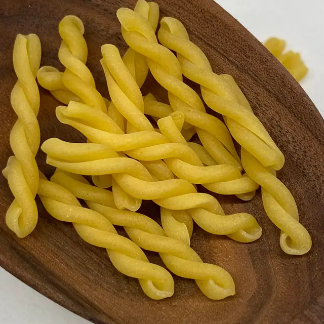 A close up shot of Gemelli in a wooden serving spoon