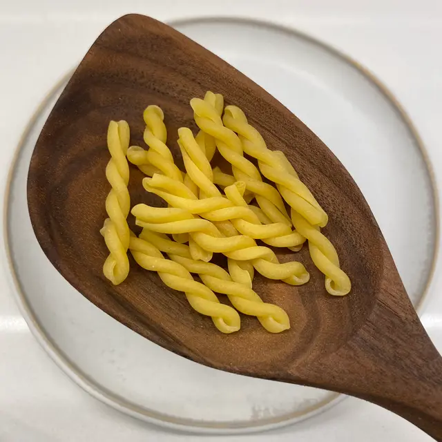 Gemelli in a wooden serving spoon