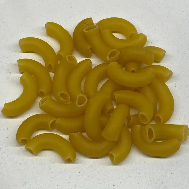 A close up shot of Large Elbow Macaroni on a white kitchen counter