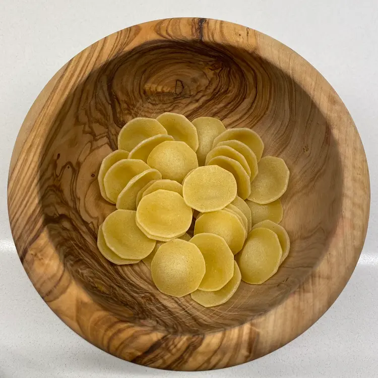 Orecchiette in a round wooden bowl