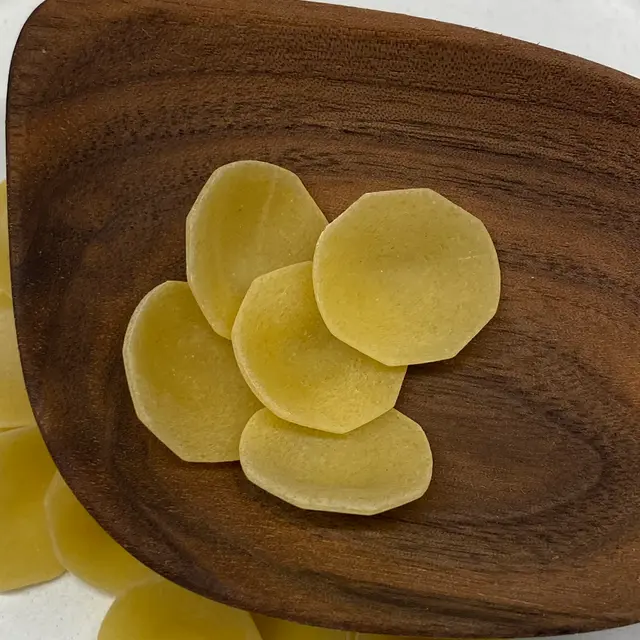 A close up shot of Orecchiette in a wooden serving spoon