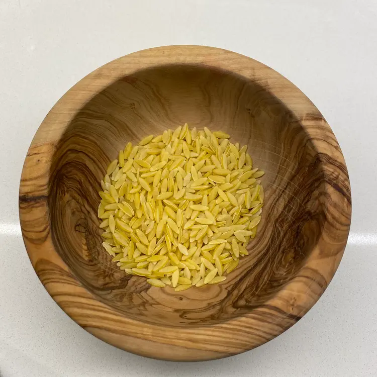 Orzo in a round wooden bowl