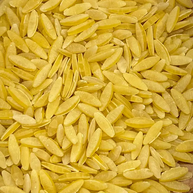 A close up shot of Orzo on a round white plate