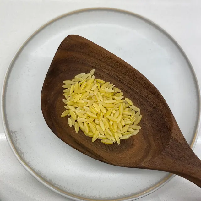 Orzo in a wooden serving spoon