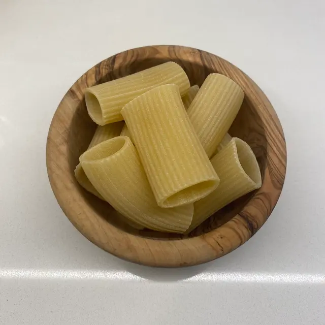 Paccheri in a round wooden bowl