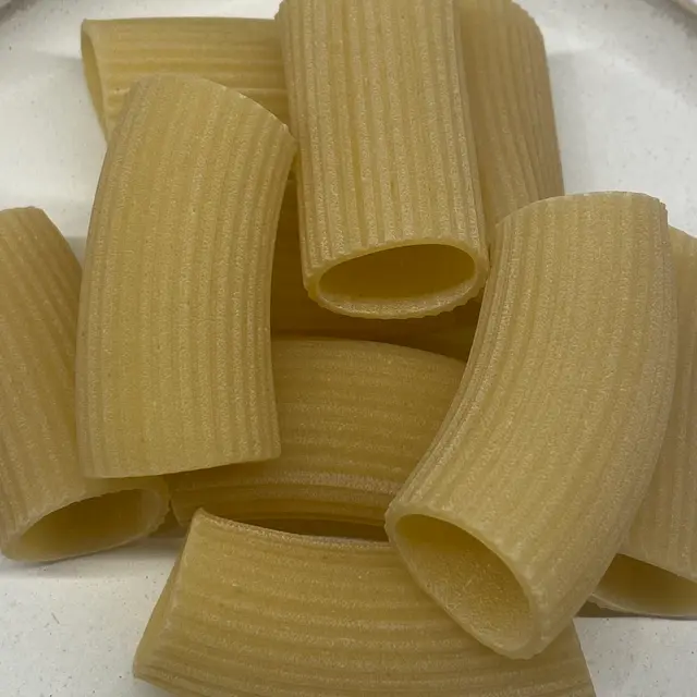 A close up shot of Paccheri on a round white plate