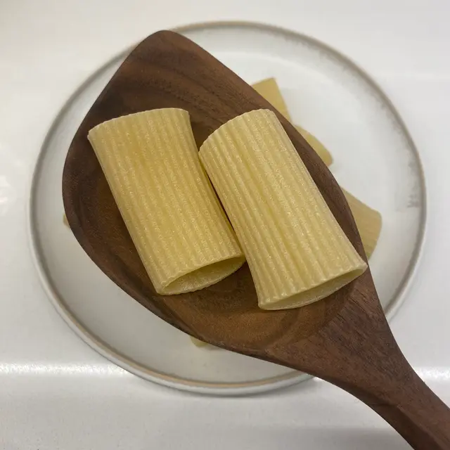 Paccheri in a wooden serving spoon