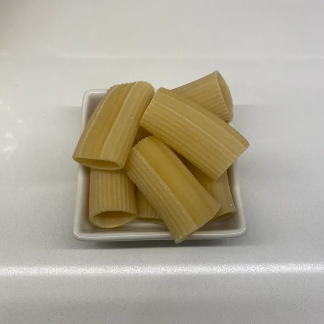 Paccheri in a square white glass bowl