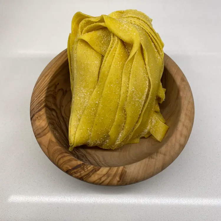 Pappardelle in a round wooden bowl