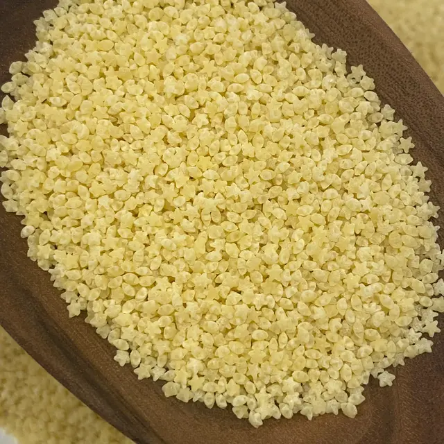 A close up shot of Pastina in a wooden serving spoon