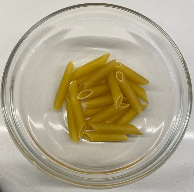 Penne in a clear round glass bowl