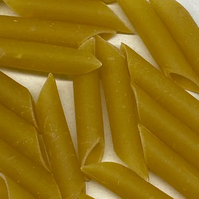 A close up shot of Penne on a round white plate