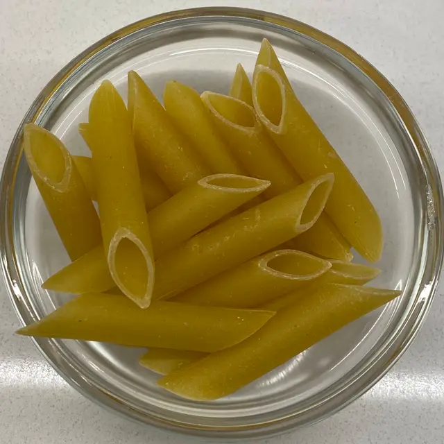 Penne in a small round white glass bowl