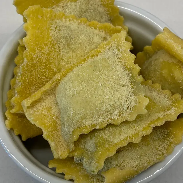 A close up shot of Ravioli in a round white ramekin