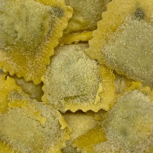 A close up shot of Ravioli on a round white plate