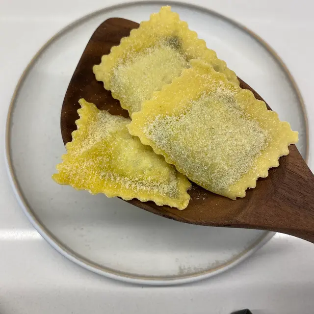 Ravioli in a wooden serving spoon