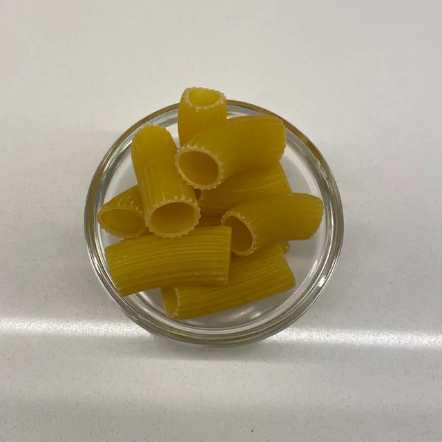 Rigatoni in a small round white glass bowl