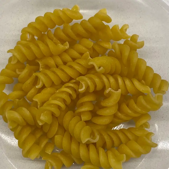 A close up shot of Rotini on a white kitchen counter