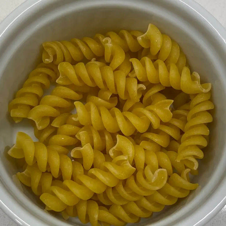 A close up shot of Rotini in a round white ramekin