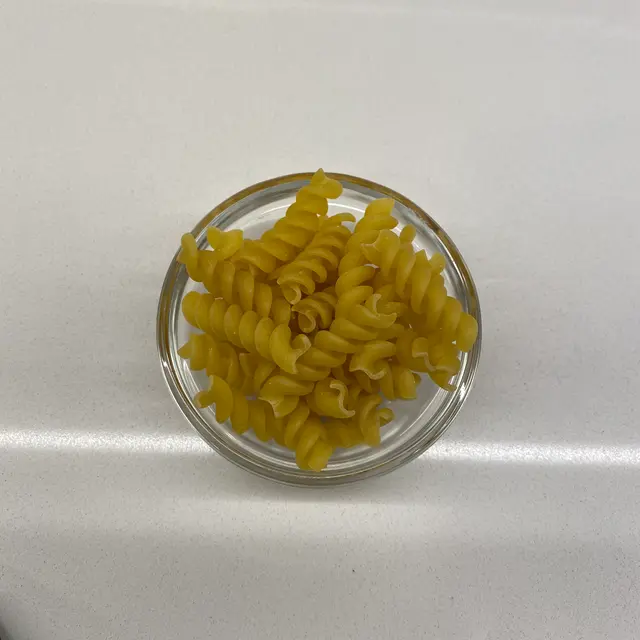 Rotini in a small round white glass bowl