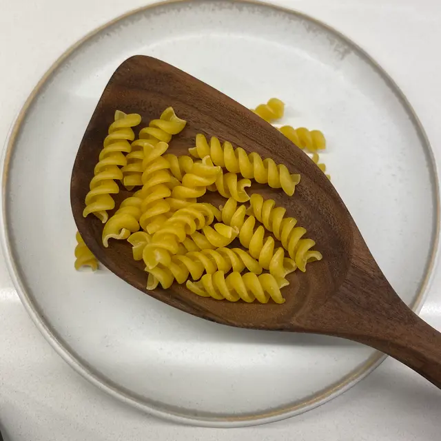 Rotini in a wooden serving spoon