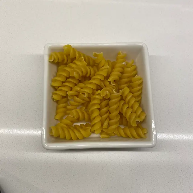 Rotini in a square white glass bowl