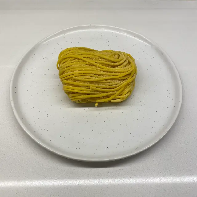 Spaghetti on a speckled white plate