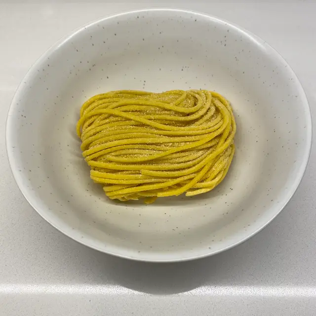 Spaghetti in a speckled white bowl