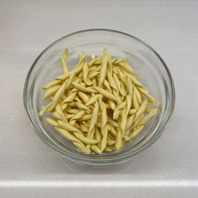 Strozzapreti in a clear round glass bowl