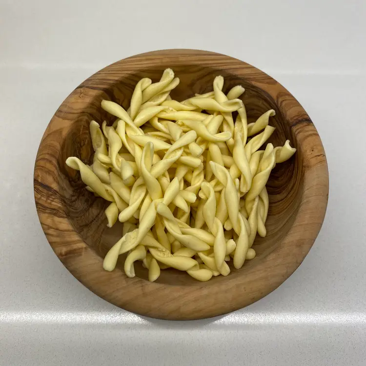 Strozzapreti in a round wooden bowl