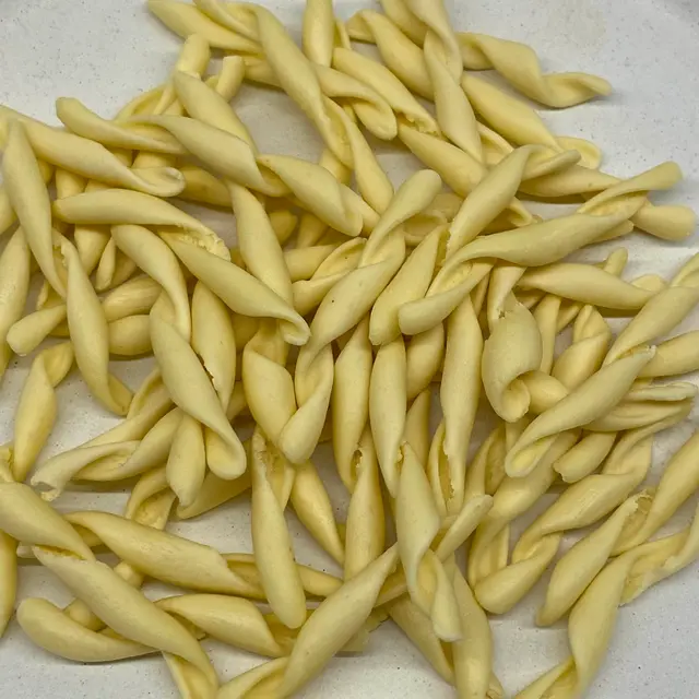 A close up shot of Strozzapreti on a round white plate