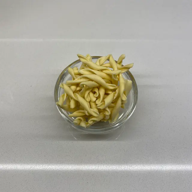 Strozzapreti in a small round white glass bowl