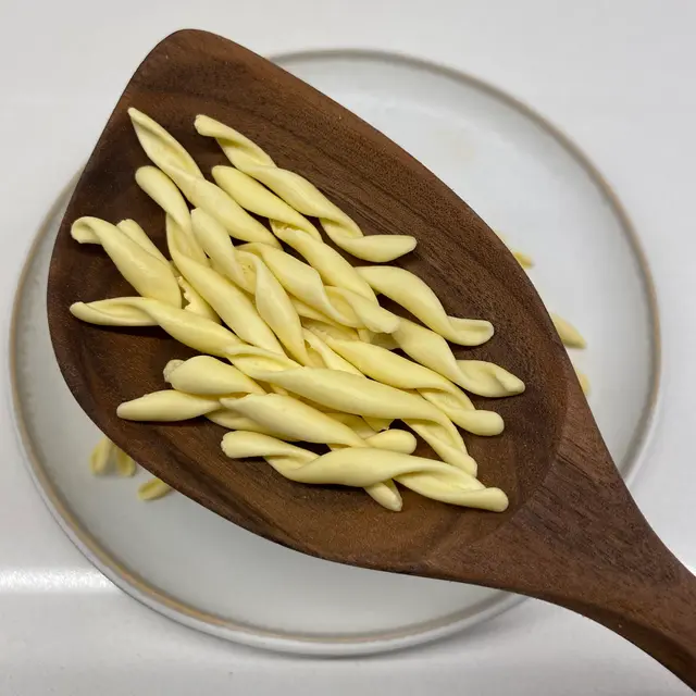 Strozzapreti in a wooden serving spoon