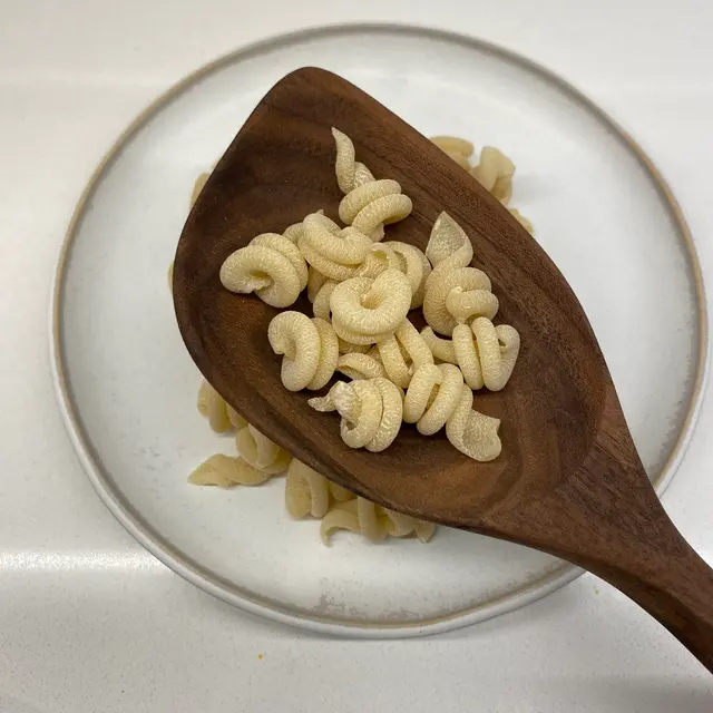 Trottole in a wooden serving spoon