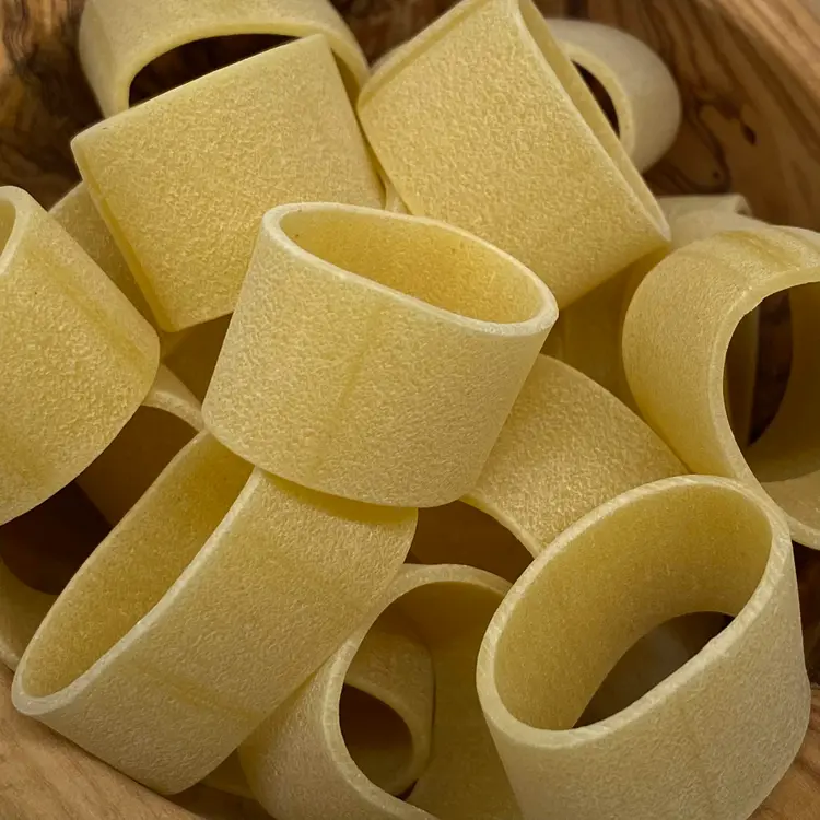 A close up shot of Calamarata in a round wooden bowl