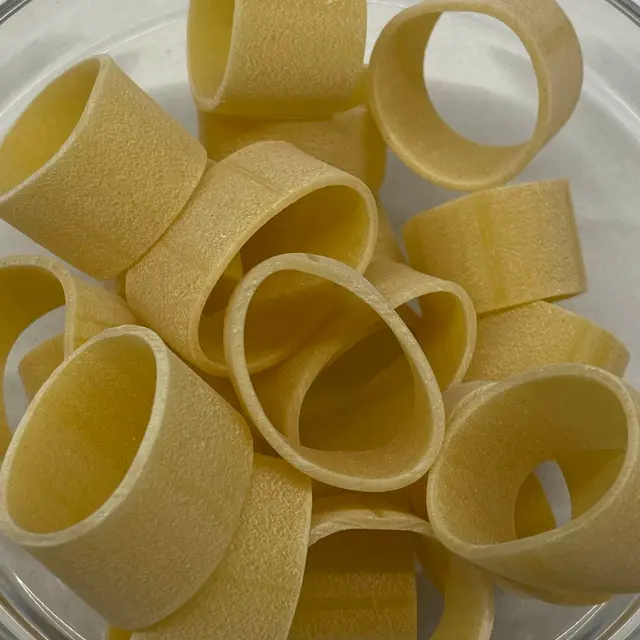 A close up shot of Calamarata in a small round white glass bowl